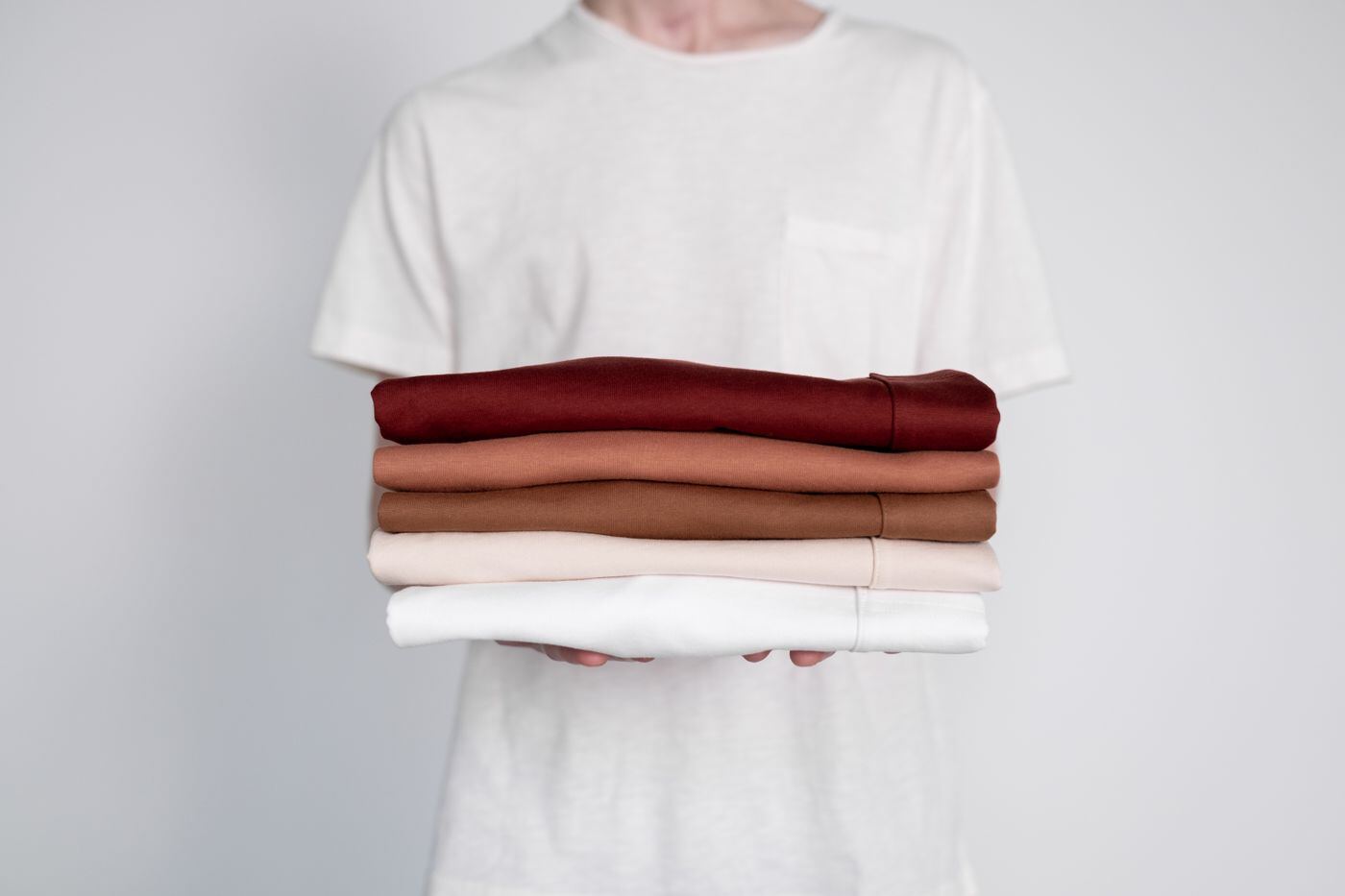 Neatly folded shirts in neutral tones